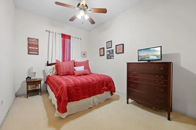 a spacious bedroom with a bed and a dresser