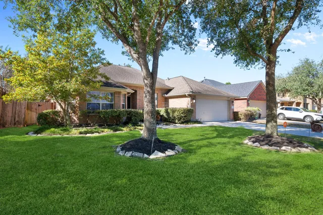 a front view of a house with a garden and tree