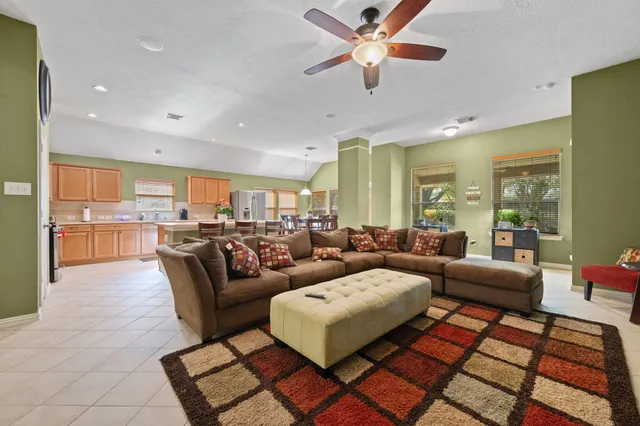 a living room with furniture and a view of kitchen