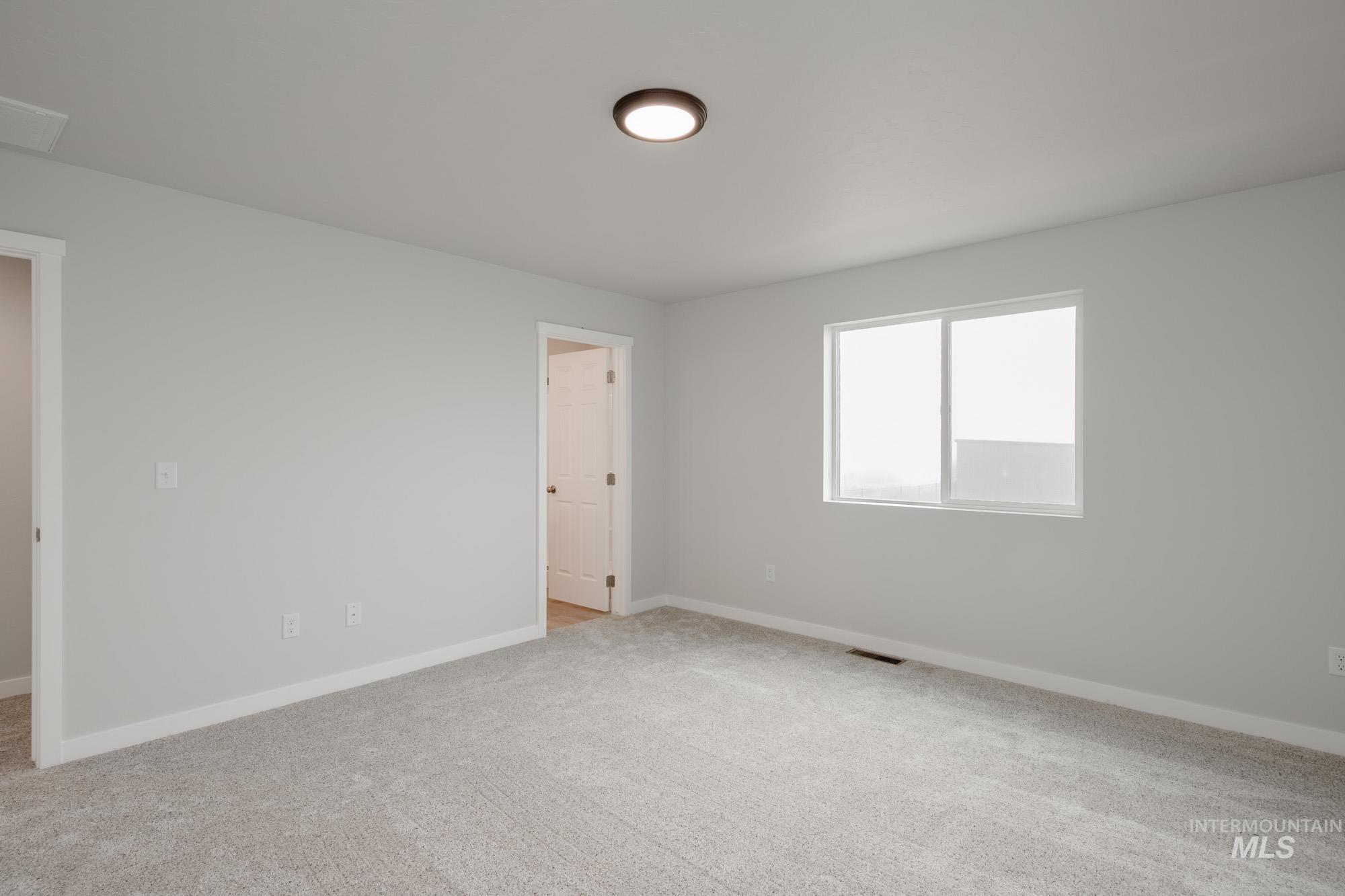 2391 West Fallon Loop Nampa, ID 83651 - Photo 17 of 20 Spacious room featuring light grey walls, white trim, and neutral grey carpet