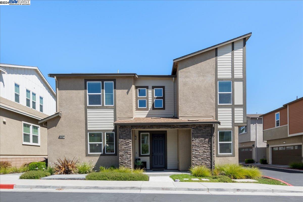 a front view of a house with garden and plants