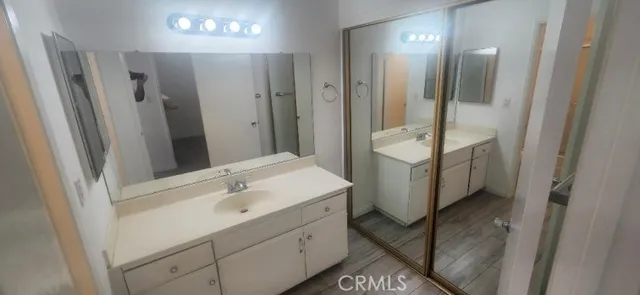 a bathroom with a sink a toilet a mirror and shower