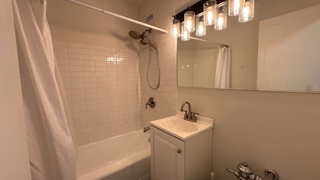 140 Chestnut Street, Unit 301 Springfield, MA 01103 - Photo 6 of 8 a bathroom with a sink a mirror and a shower