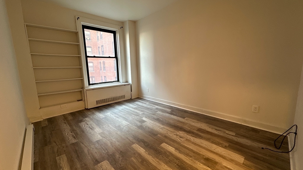 140 Chestnut Street, Unit 301 Springfield, MA 01103 - Photo 7 of 8 an empty room with wooden floor and windows