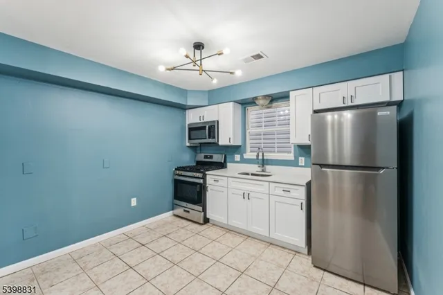 a kitchen with stainless steel appliances a refrigerator sink and microwave
