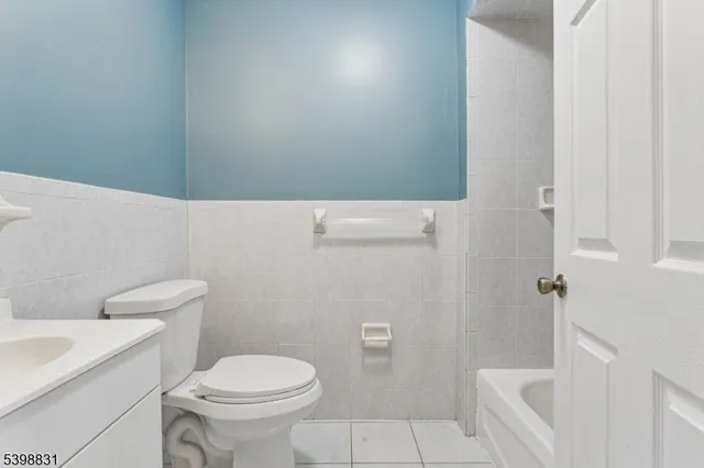 a white toilet sitting next to a white sink and vanity