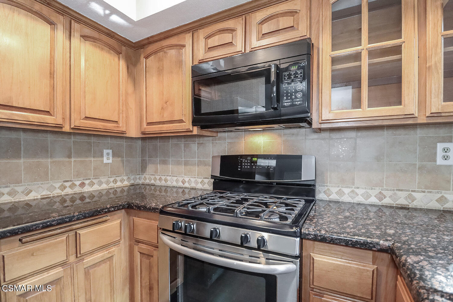1195 Fitzgerald Road, Unit E Simi Valley, CA 93065 - Photo 8 of 19 a kitchen with granite countertop a stove and a microwave