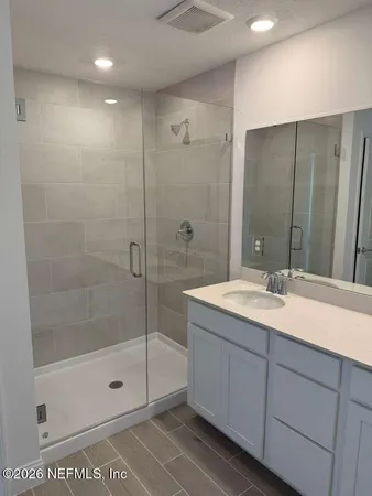 a bathroom with a shower sink and mirror