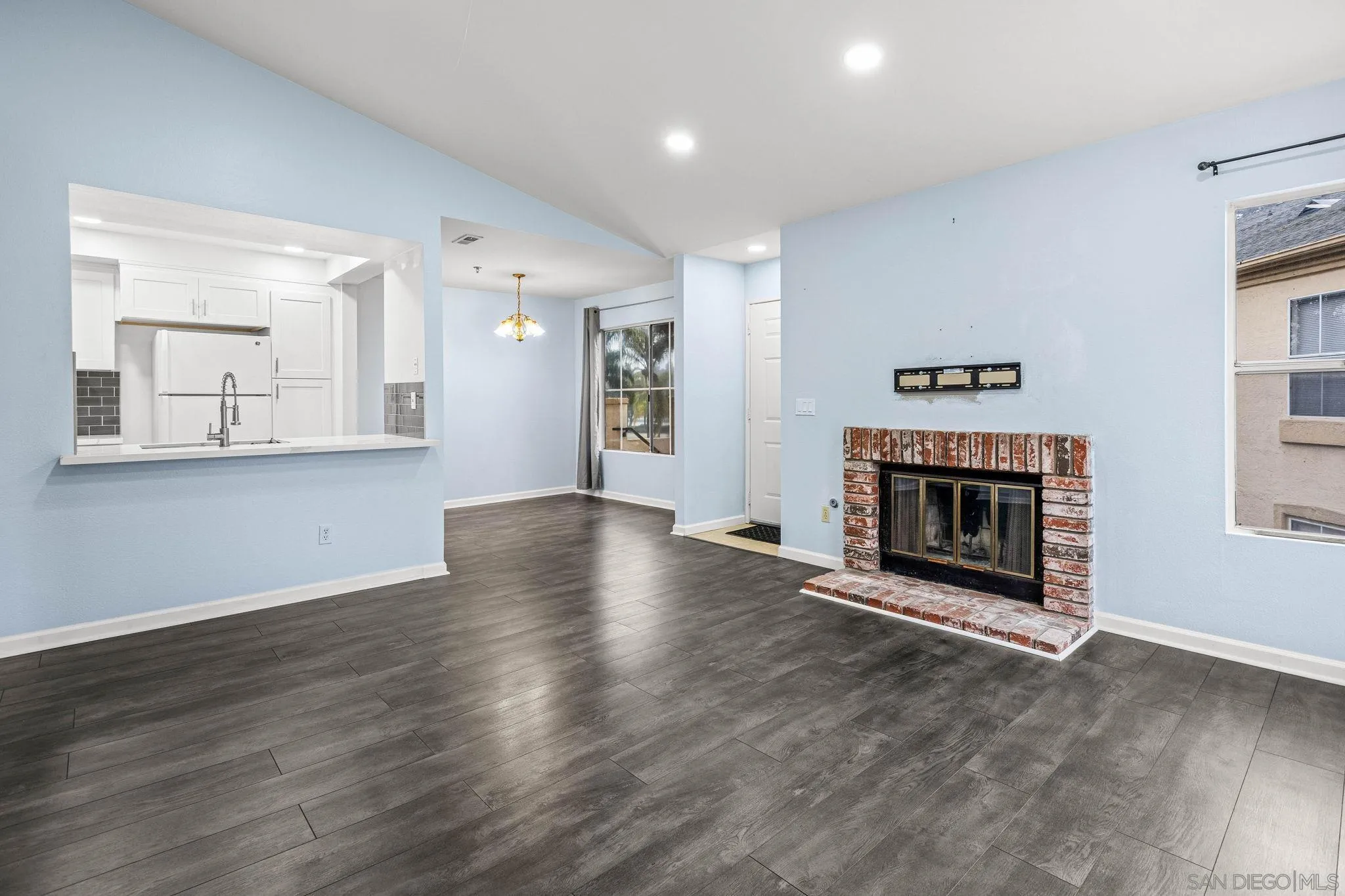 719 Brookstone Road, Unit 203 Chula Vista, CA 91913 - Photo 8 of 23 an empty room with wooden floor and a fireplace