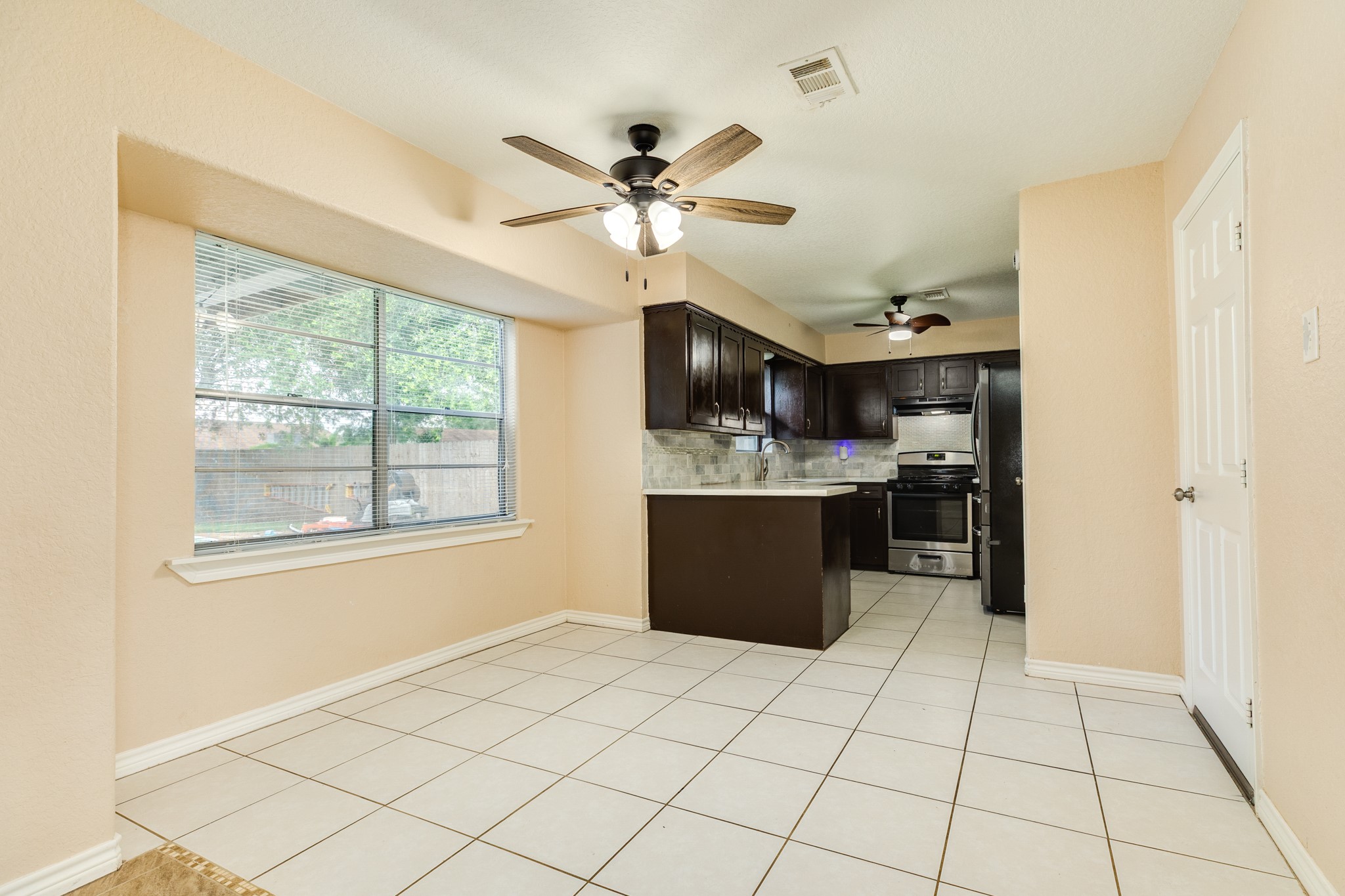 128 Houston Street Angleton, TX 77515 - Photo 15 of 25 a view of kitchen with stainless steel appliances kitchen island granite countertop cabinets and window