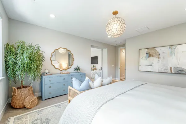 a large living room with stainless steel appliances furniture a couch and a kitchen view