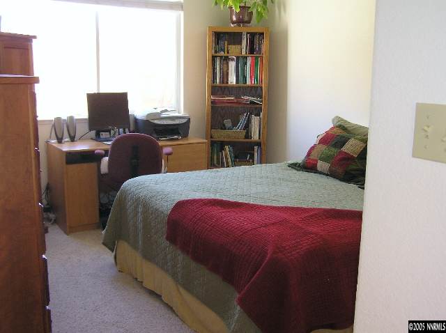 7234 Heatherwood Drive Reno, NV 89523 - Photo 4 of 9 a bed sitting in a bedroom next to a computer on a desk