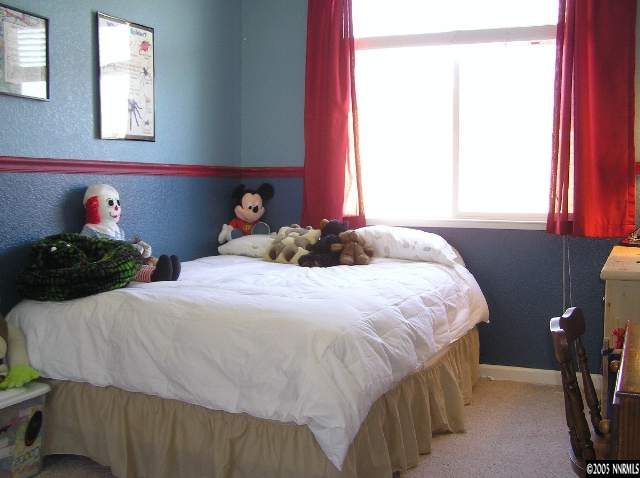 7234 Heatherwood Drive Reno, NV 89523 - Photo 6 of 9 a bedroom with a bed a dresser and a window