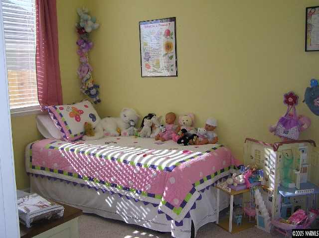 7234 Heatherwood Drive Reno, NV 89523 - Photo 7 of 9 a bedroom with a bed and a potted plant
