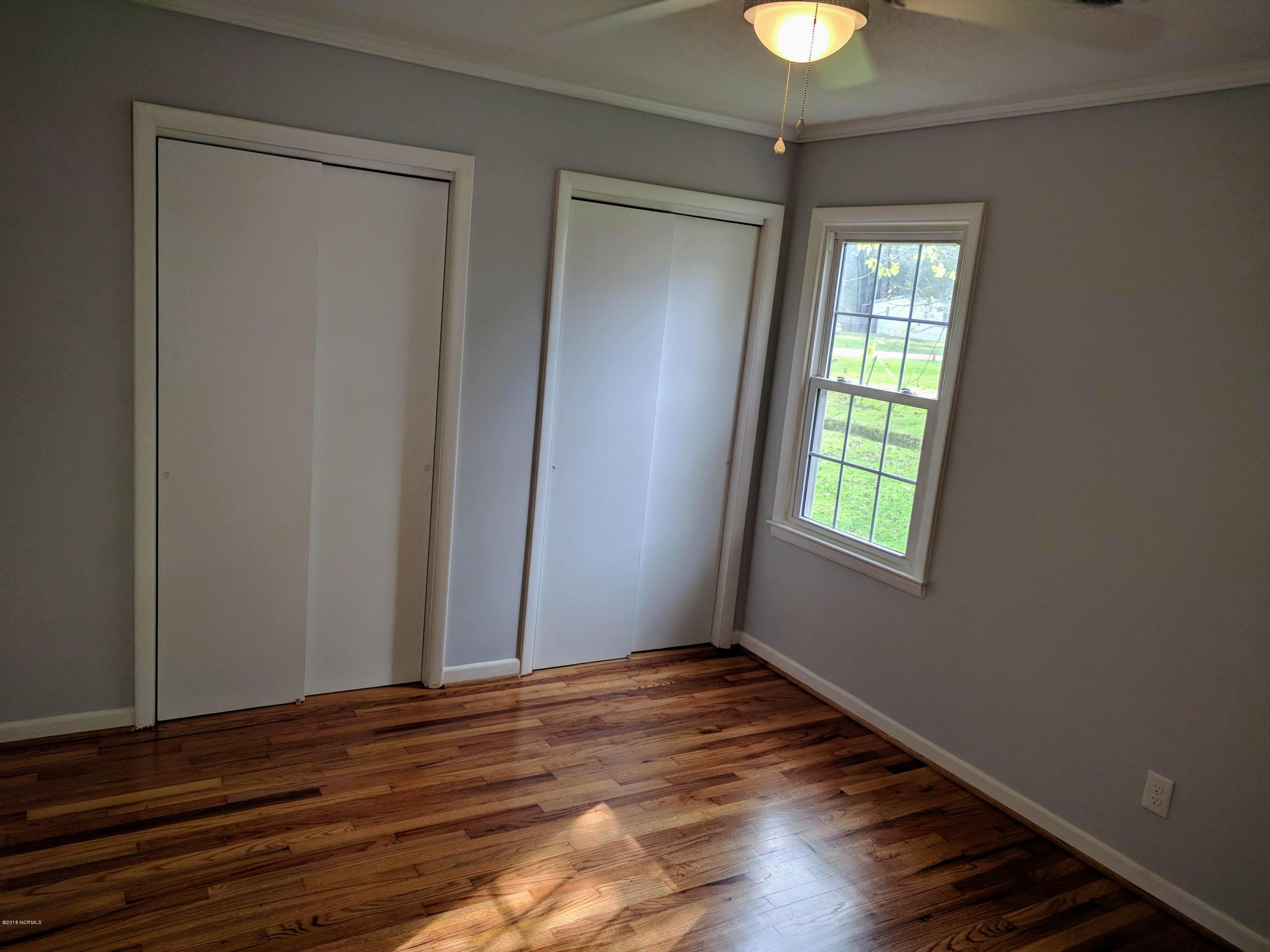 706 Tully Hill Road Kinston, NC 28504 - Photo 13 of 16 Double closets in the rear bedroom with sliding doors.