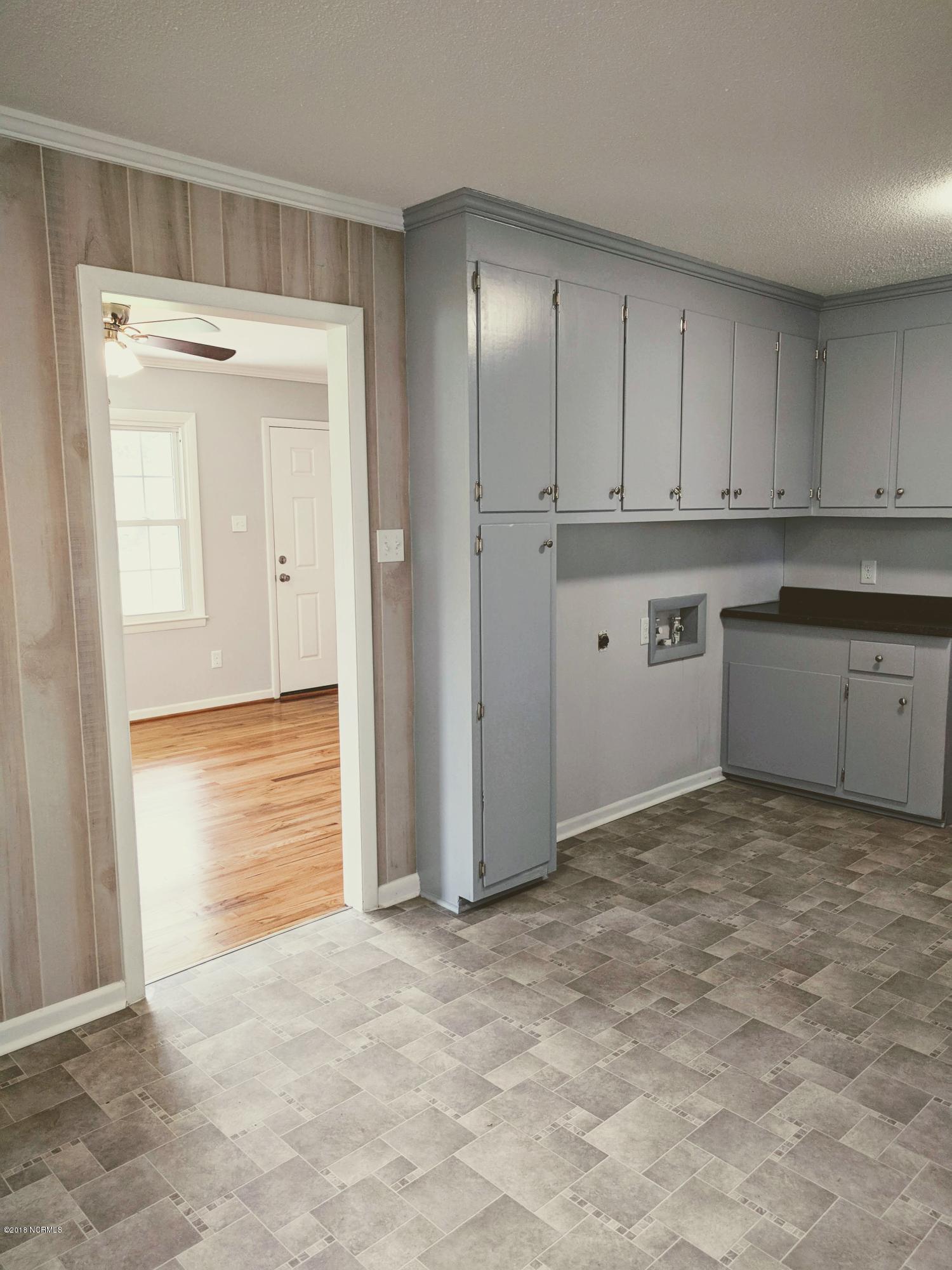 706 Tully Hill Road Kinston, NC 28504 - Photo 7 of 16 Looking from the dining room into the living room. Washer/Dryer hook up in the kitchen.