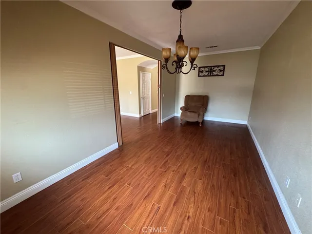 a view of a room with wooden floor a ceiling fan and stairs