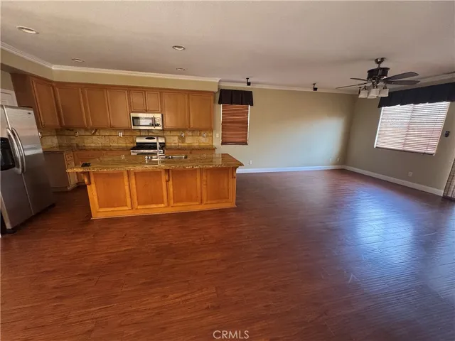 a view of kitchen with stainless steel appliances granite countertop a stove top oven a sink and a microwave