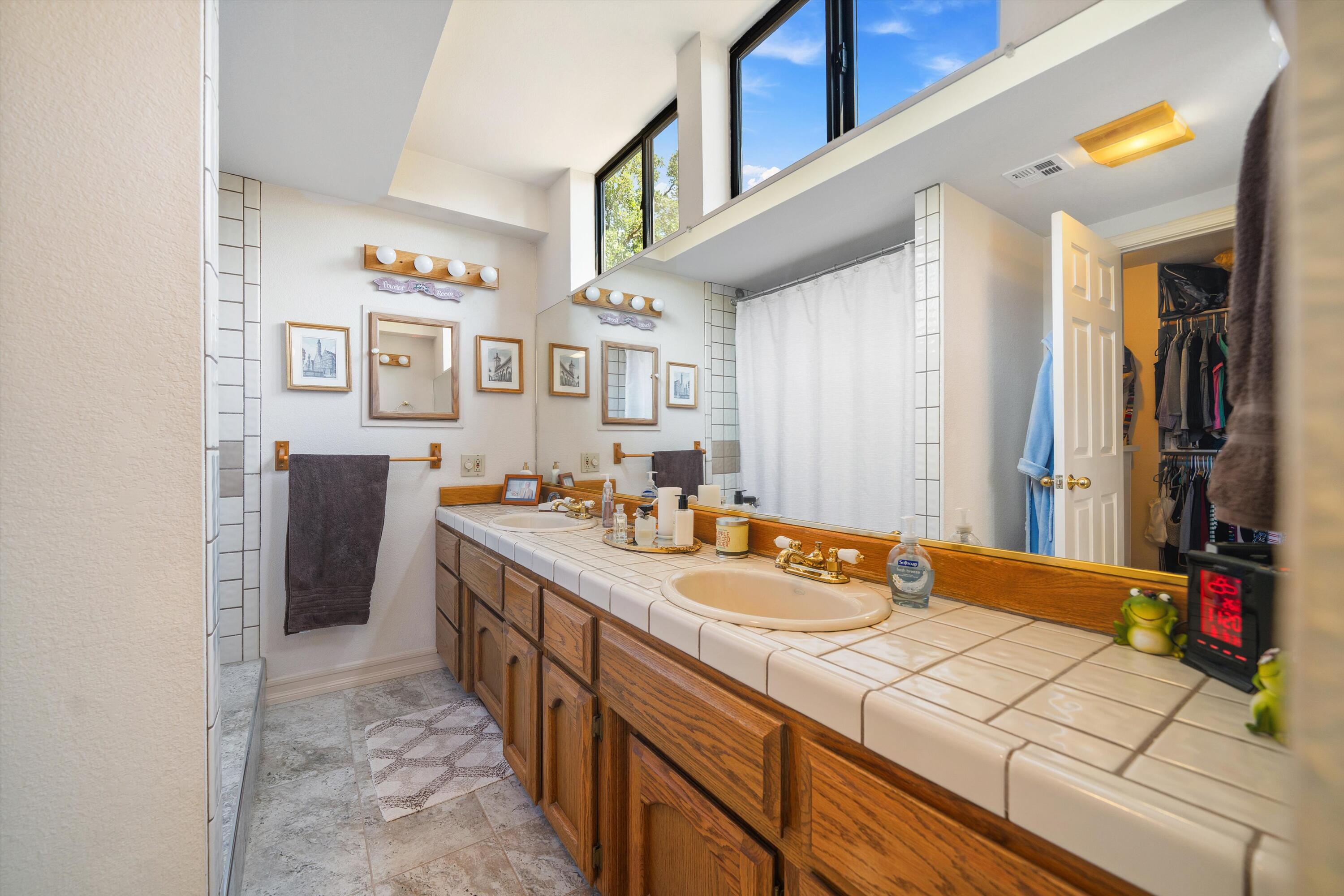 26460 Brian Place Tehachapi, CA 93561 - Photo 24 of 50 a spacious bathroom with a double vanity sink and a mirror