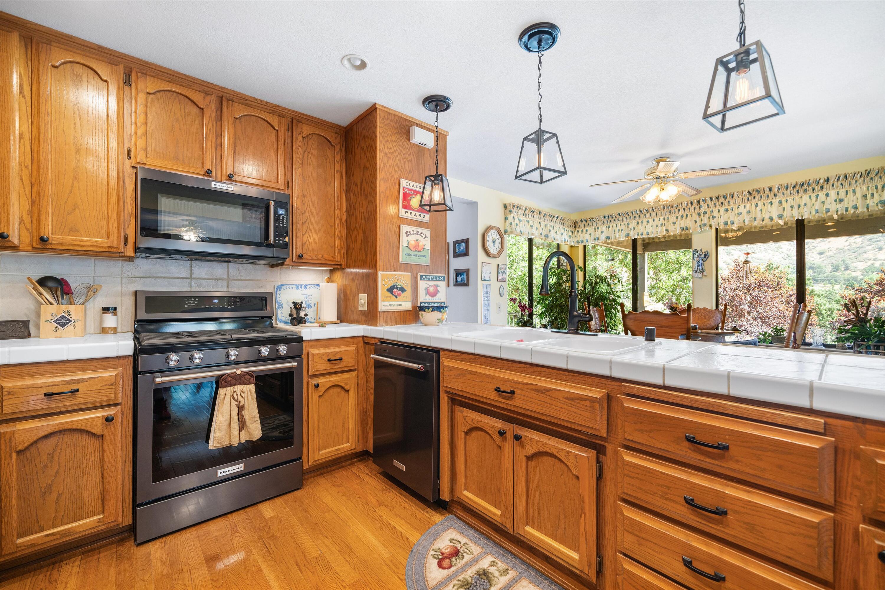 26460 Brian Place Tehachapi, CA 93561 - Photo 10 of 50 a kitchen with stainless steel appliances granite countertop a stove a sink and a microwave