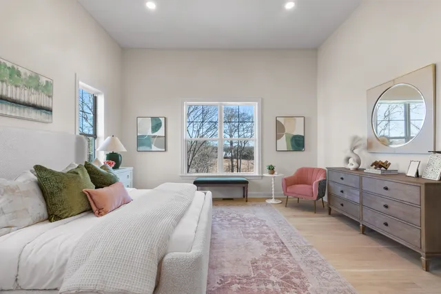 a bedroom with a bed large mirror and lamp