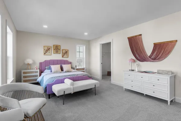 a bedroom with a bed and large windows