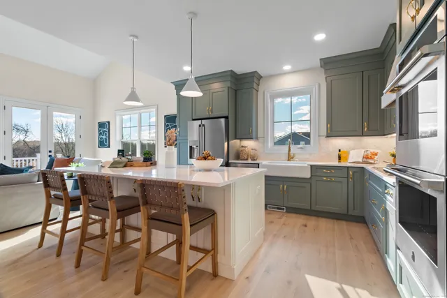 a kitchen with stainless steel appliances granite countertop a stove and a wooden floors
