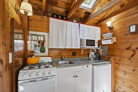 a kitchen with stainless steel appliances a stove a sink and white cabinets