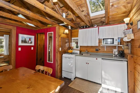 a utility room with stainless steel appliances granite countertop a sink a refrigerator and cabinets