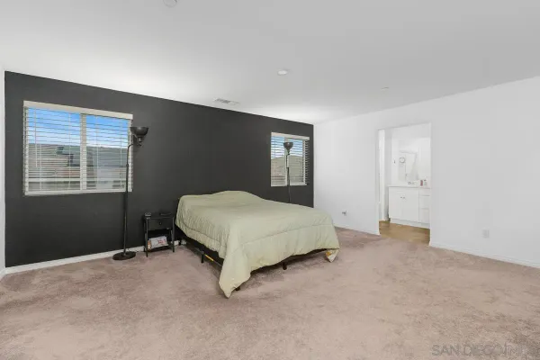 a spacious bedroom with a bed and a window
