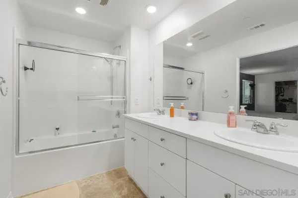 a bathroom with a shower sink and mirror