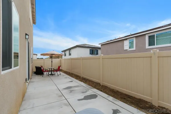 a backyard of a house with a table and chairs