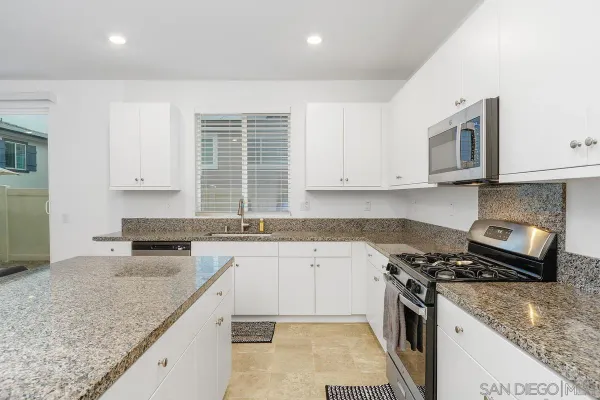 a kitchen with stainless steel appliances granite countertop a sink stove and cabinets