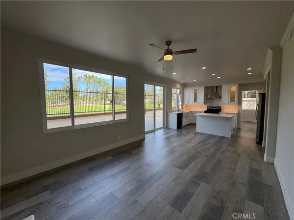 a view of a big room with wooden floor and windows