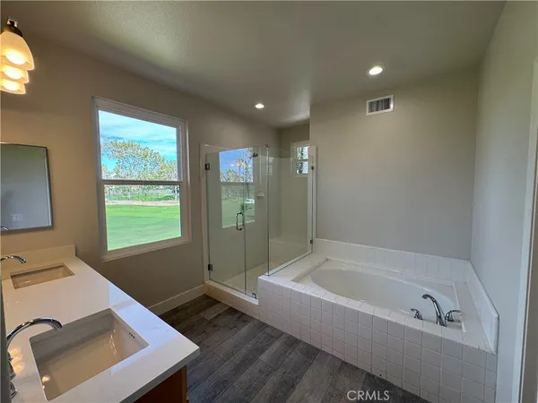 a bathroom with a tub sink and mirror