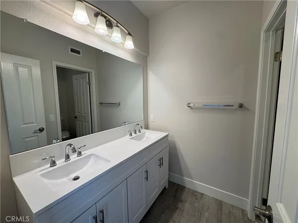 a spacious bathroom with a double vanity sink and a mirror