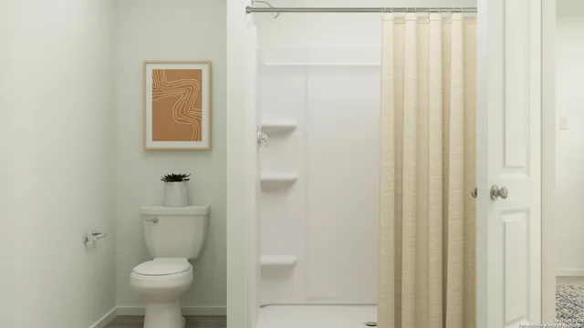 a bathroom with a toilet and a shower