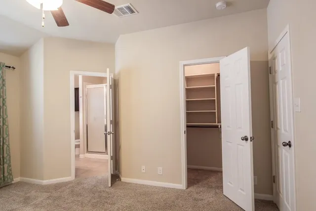 an empty room with windows and fan