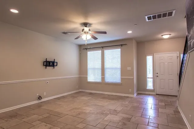 a view of a livingroom with a chandelier fan and windows