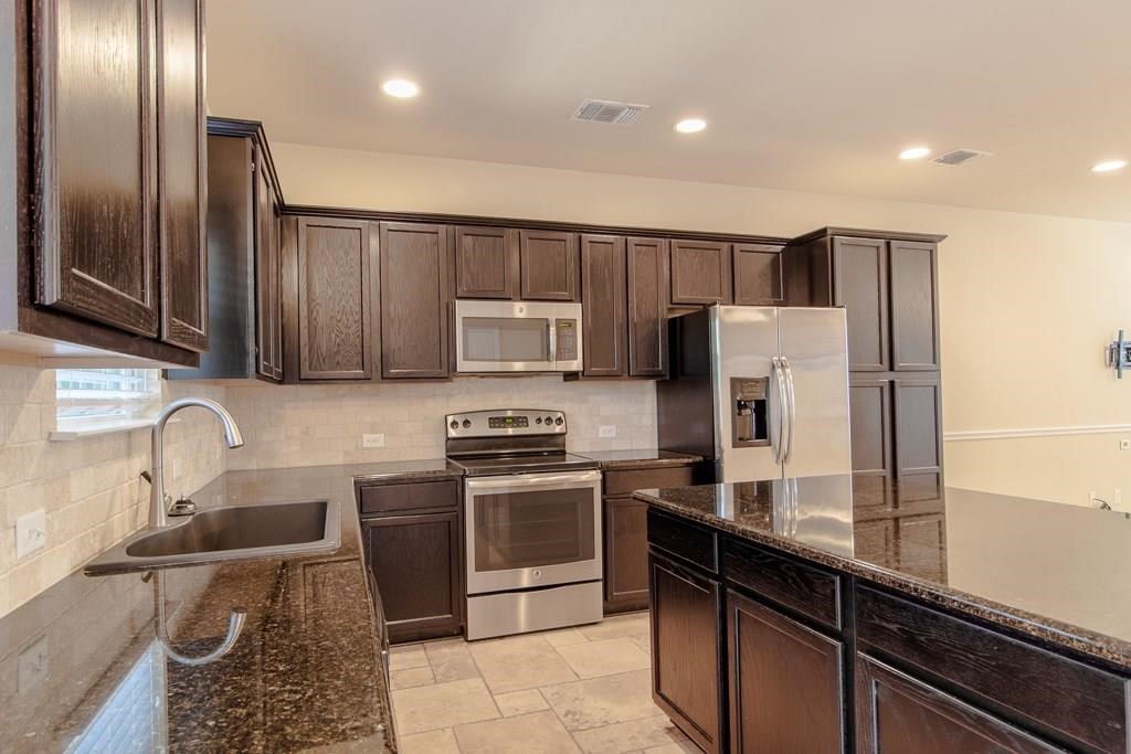 636 Lookout Tree Lane Round Rock, TX 78664 - Photo 9 of 23 a kitchen with stainless steel appliances granite countertop a refrigerator sink and stove