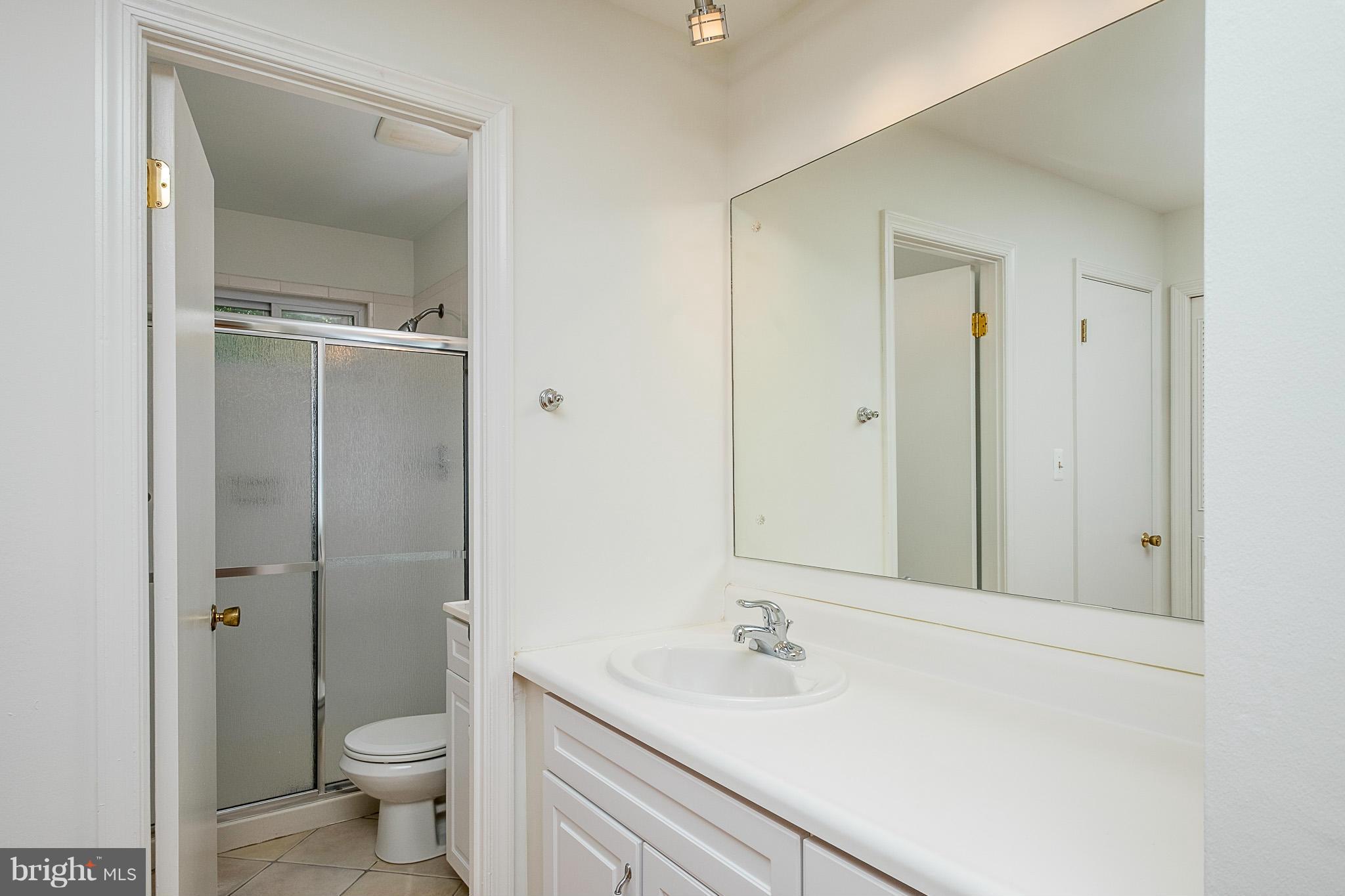 1412 Winding Waye Lane Silver Spring, MD 20902 - Photo 14 of 30 a bathroom with a granite countertop sink toilet and shower