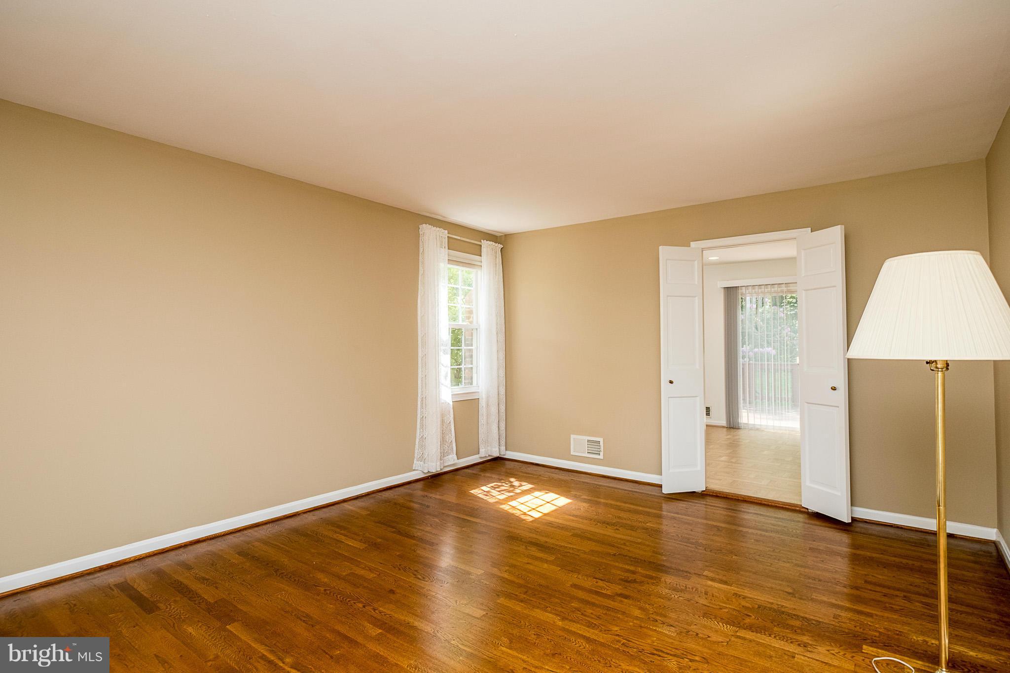 1412 Winding Waye Lane Silver Spring, MD 20902 - Photo 4 of 30 a view of an empty room with wooden floor and a window
