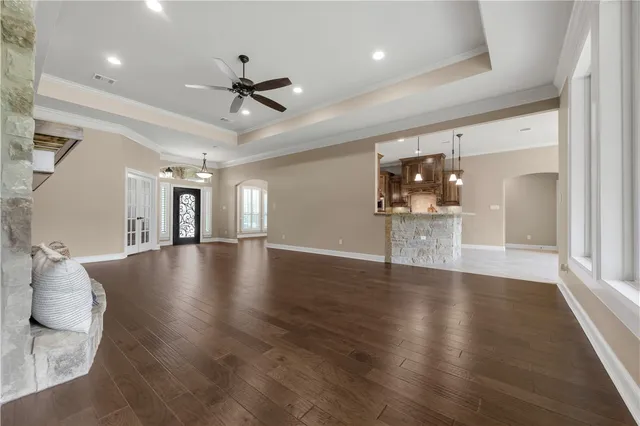a view of a livingroom with wooden floor and a ceiling fan