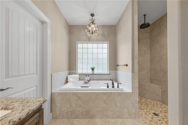 a bathroom with a granite countertop bathtub a sink and a window