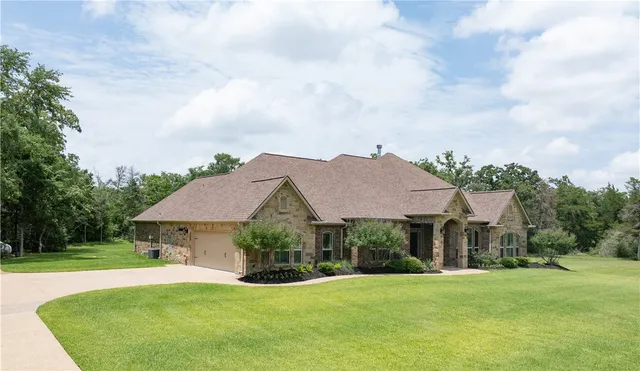 a front view of a house with yard and green space