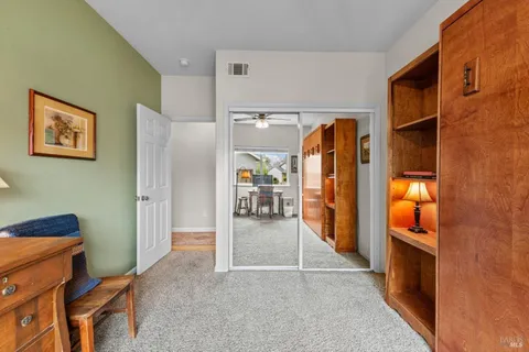 a bedroom with a bed flat screen tv and a large window