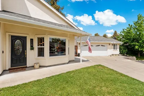 a front view of a house with a porch and a yard