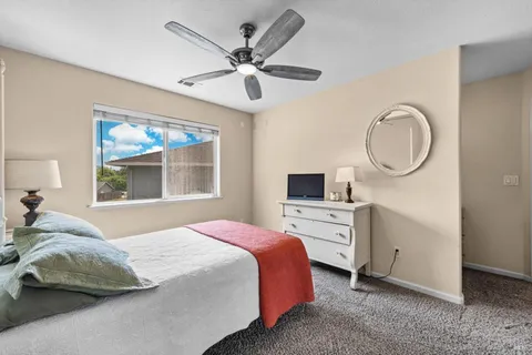 a spacious bedroom with a bed a couch and a chandelier