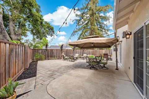 a view of a patio with table and chairs with wooden fence