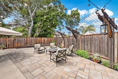 a view of backyard with table and chairs under an umbrella